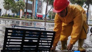 海口“小黄人”打开雨水井盖打好“排涝战”